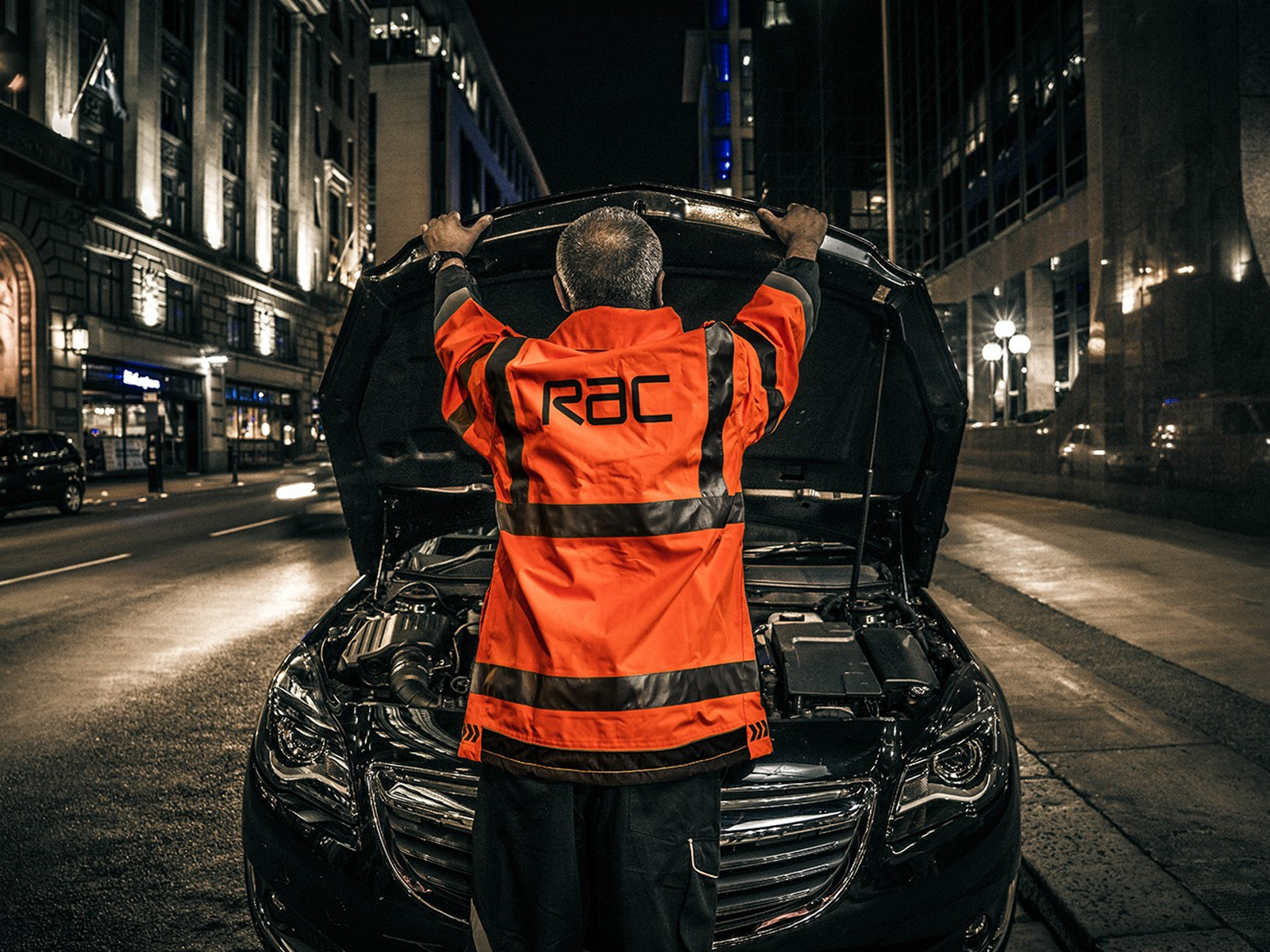 An RAC operator looking at a broken down car at the side of the road